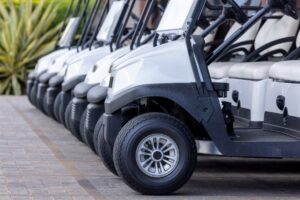 Line of parked golf carts ready for use.